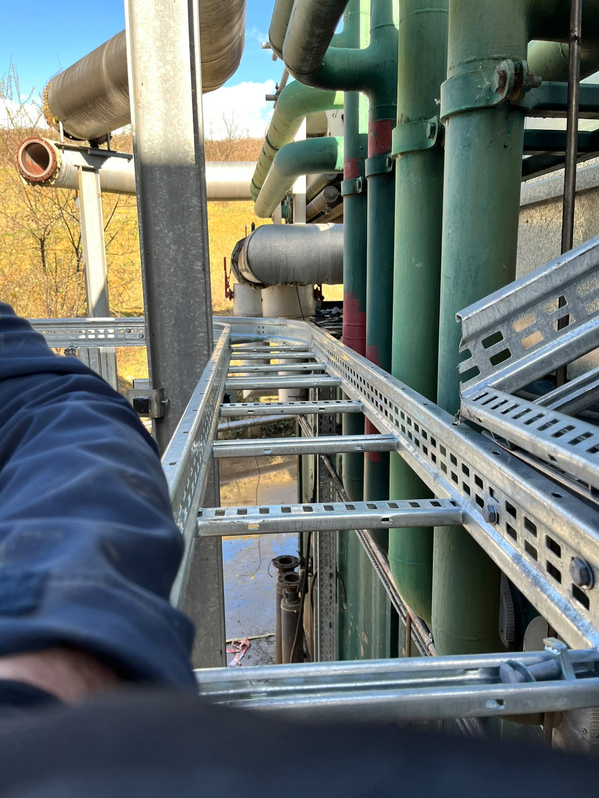 Installed cable tray between process pipes